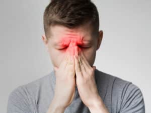 Frustrated young man suffering from sinus pressure