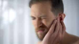 Man experiencing pain and dizziness from an ear infection.