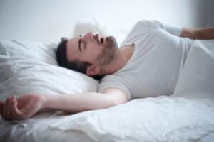 Man sleeping in bed and snoring due to deviated septum
