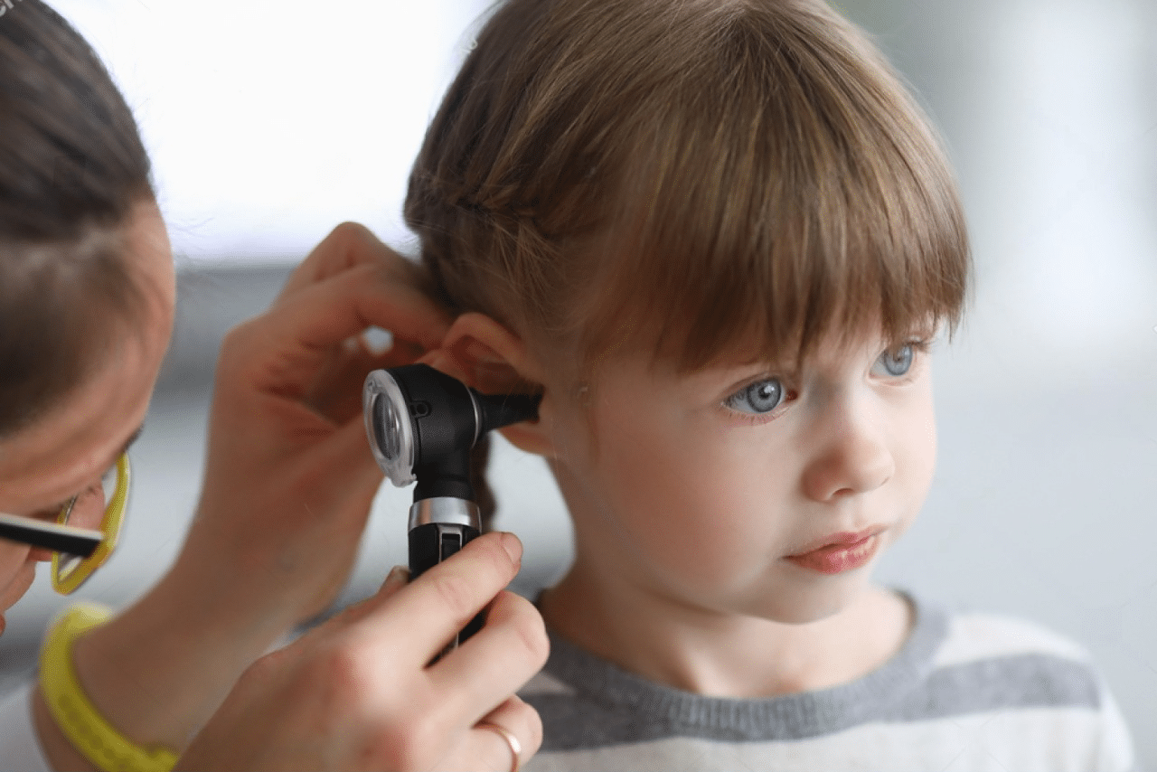 Doctor examining young boy’s ear to see ear infection
